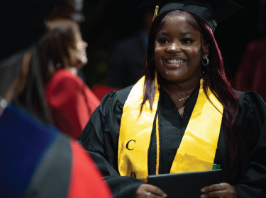Girl smiling in a graduation cap and gown